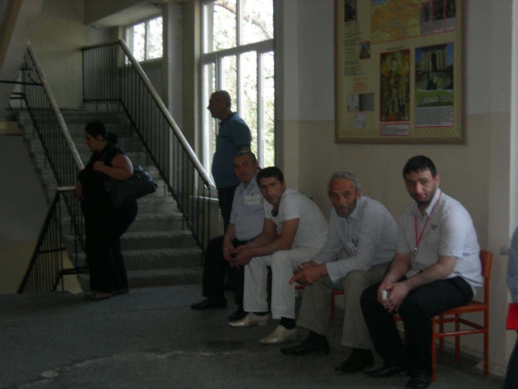 կապույտ հագուստով  կանգնած անձը որևէ փաստաթուղթ չունի, բայց հետևում է ընտրությունների ընթացքին, և փաստացի գտնվում է ընտրատեղամասում