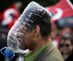 A Turkish demonstrator covers his face with a makeshift gas mask made from a large plastic bottle as protests resumed in Kizilay square in Ankara June 9, 2013 on the day Prime Minister Recep Tayyip Erdogan arrived in Ankara. Erdogan warned today that the patience of his Islamic-rooted government 